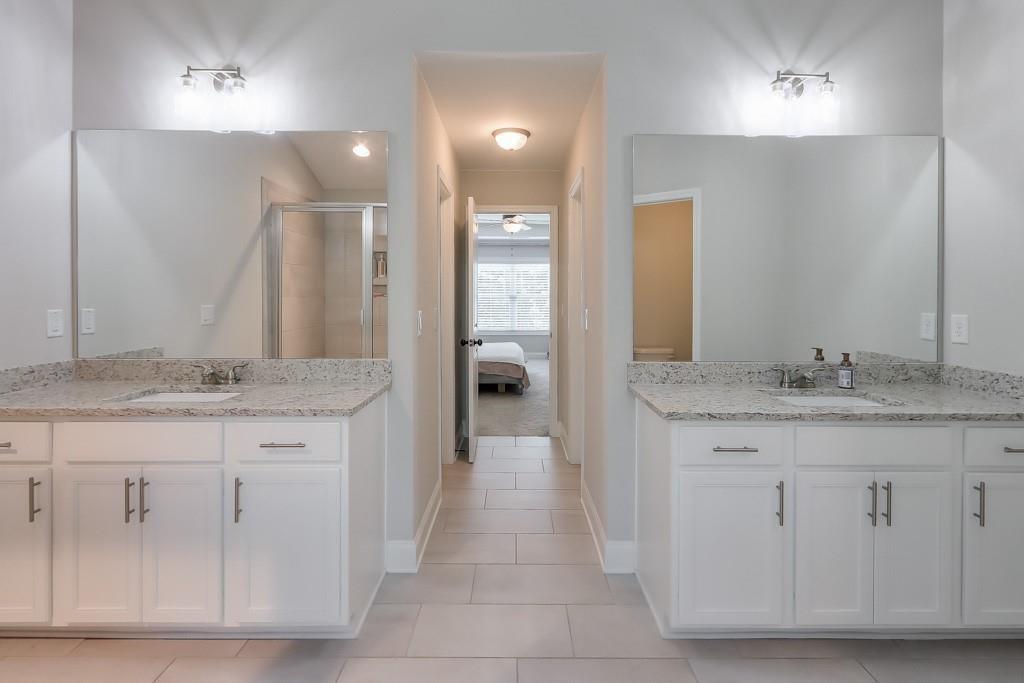 4688 Cantrell Road Flowery Branch, GA 30542 - Photo 25 of 39 a bathroom with a granite countertop sink a toilet and a vanity