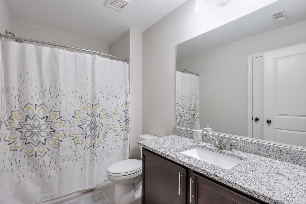 4688 Cantrell Road Flowery Branch, GA 30542 - Photo 28 of 39 a bathroom with a granite countertop sink toilet and mirror