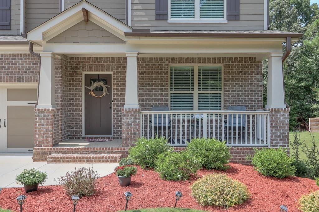 4688 Cantrell Road Flowery Branch, GA 30542 - Photo 6 of 39 a front view of a house with a large window and potted plants