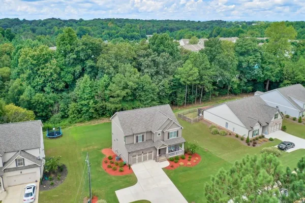 an aerial view of residential houses with outdoor space and trees