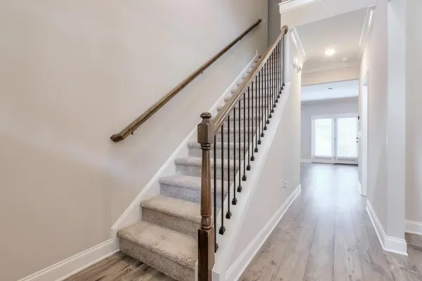 a view of staircase with wooden floor and white walls