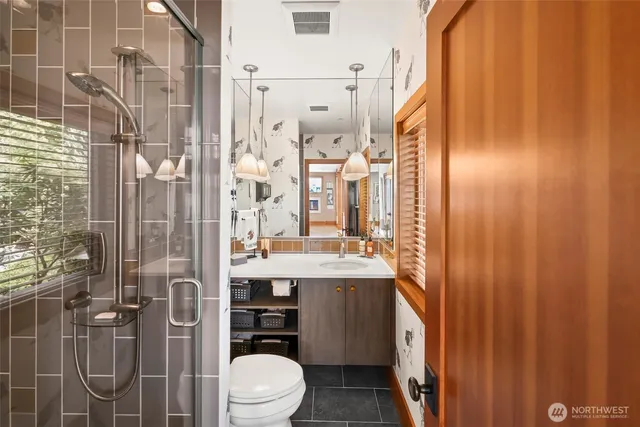 a bathroom with a sink a toilet and shower