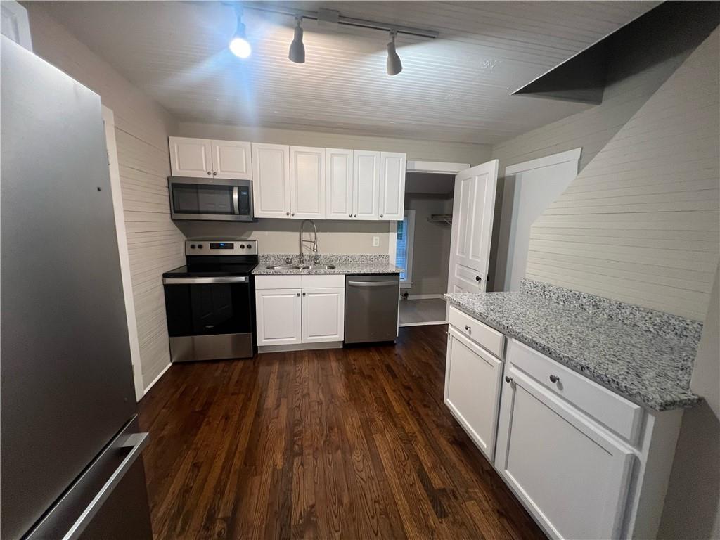 21 Quarry Street Gainesville, GA 30501 - Photo 3 of 8 a kitchen with stainless steel appliances a stove top oven a sink a refrigerator white cabinets and wooden floor