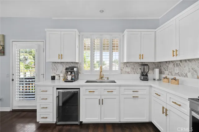 a kitchen with cabinets appliances a sink and a window