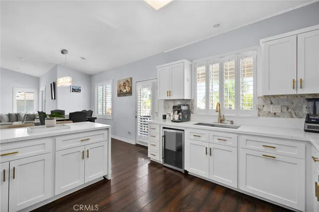 a kitchen with white cabinets sink and appliances