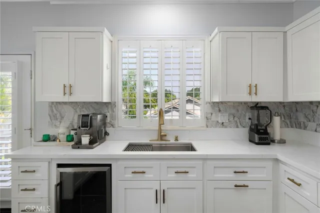 a kitchen with stainless steel appliances white cabinets and a window