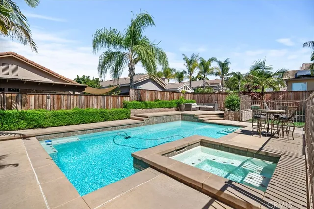 a view of a swimming pool with a patio and a yard