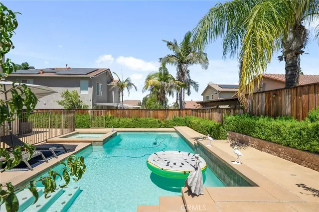 a view of a backyard with swimming pool and patio