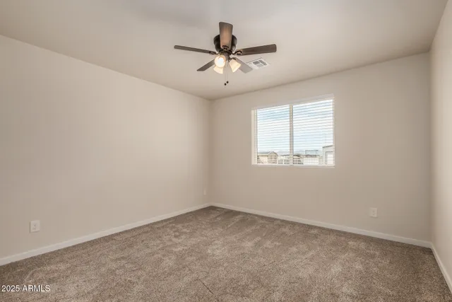 an empty room with a window and a ceiling fan