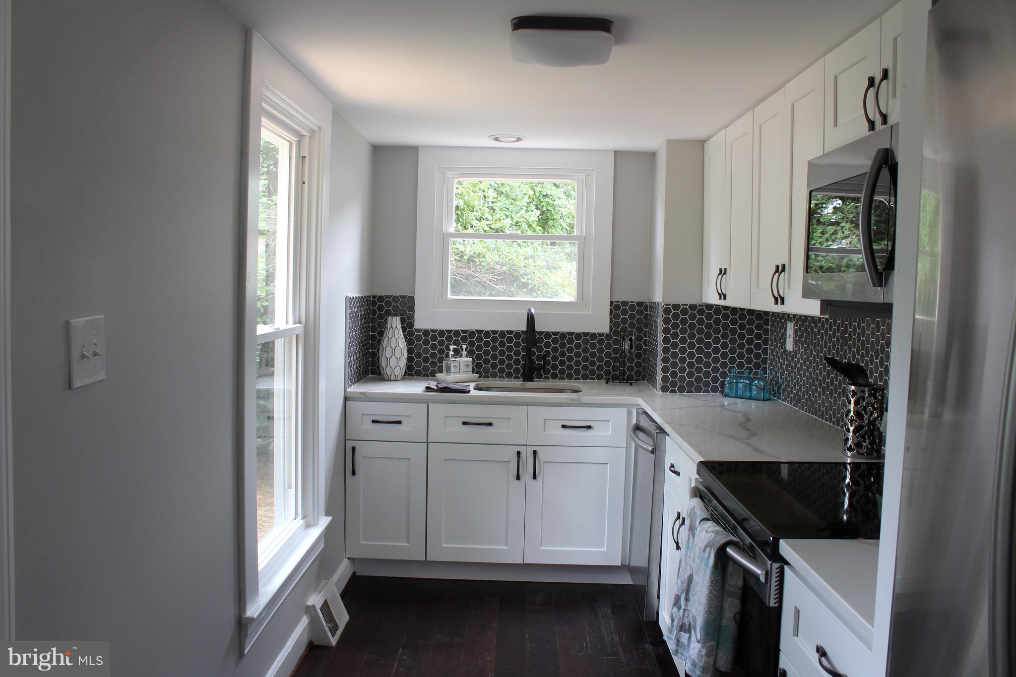 7530 East Battle Grove Road Dundalk, MD 21222 - Photo 2 of 27 a kitchen with a white cabinets and window