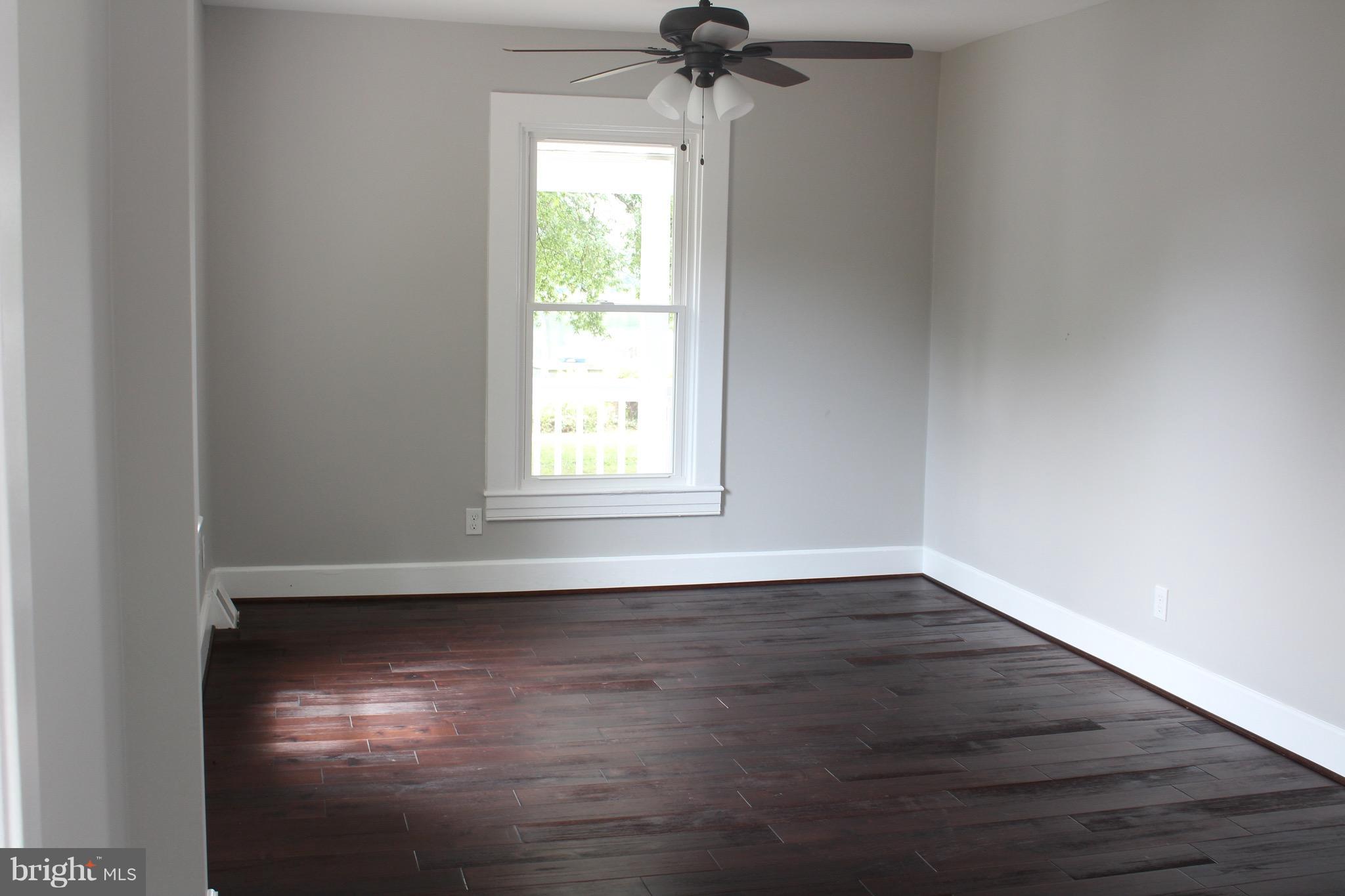7530 East Battle Grove Road Dundalk, MD 21222 - Photo 11 of 27 wooden floor in an empty room with a window