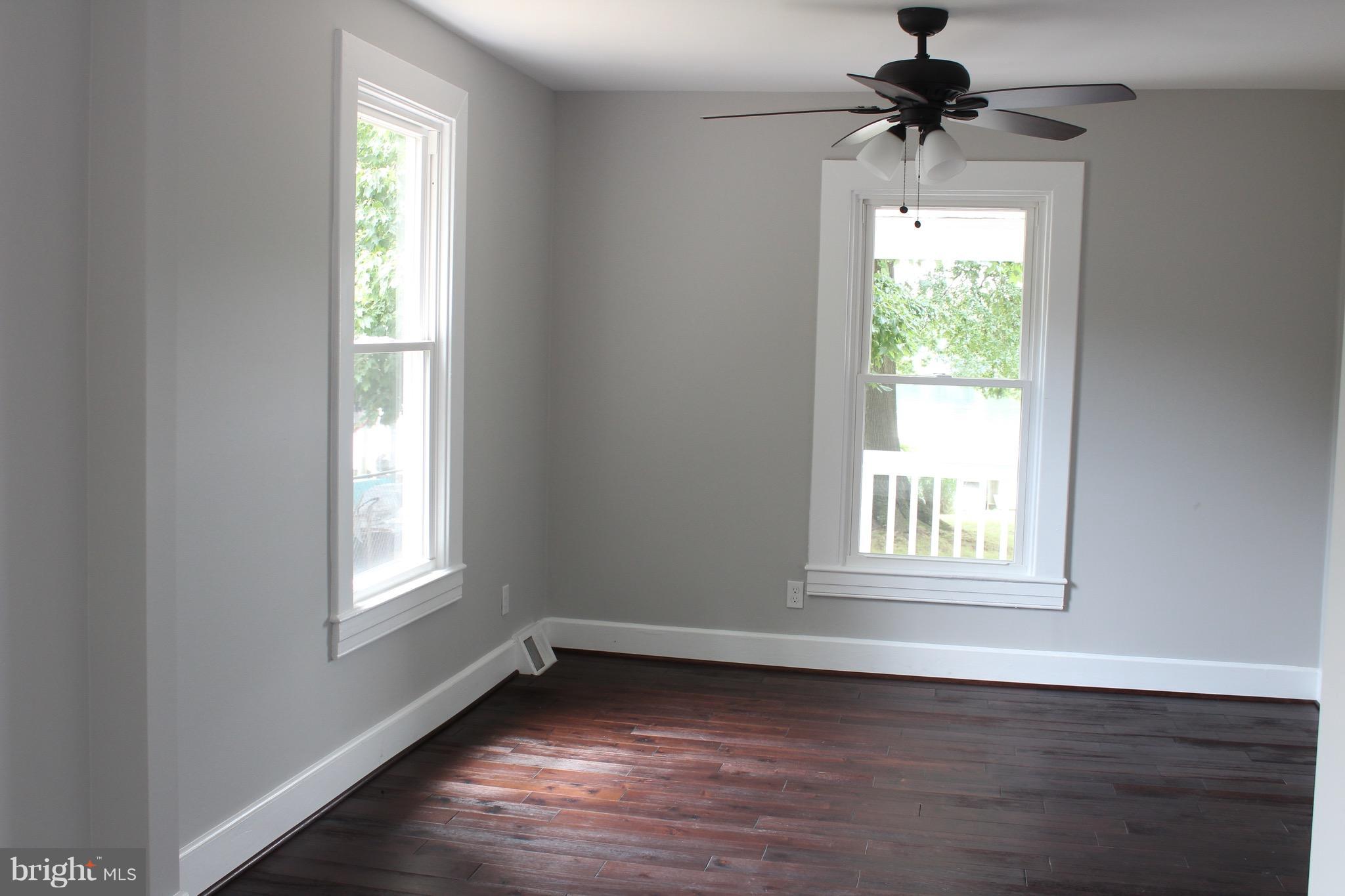 7530 East Battle Grove Road Dundalk, MD 21222 - Photo 12 of 27 a view of an empty room with wooden floor and a window