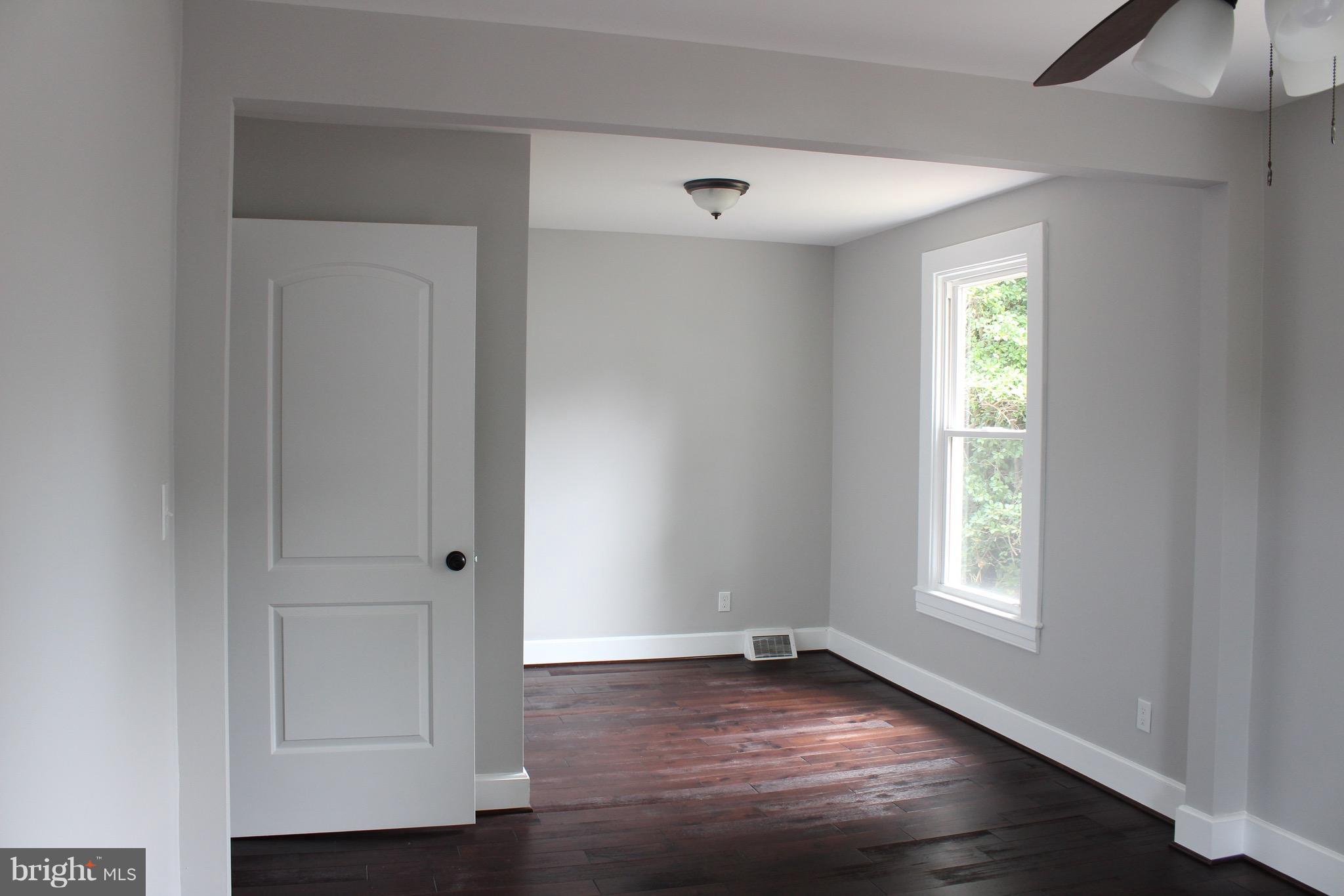 7530 East Battle Grove Road Dundalk, MD 21222 - Photo 13 of 27 an empty room with wooden floor and window