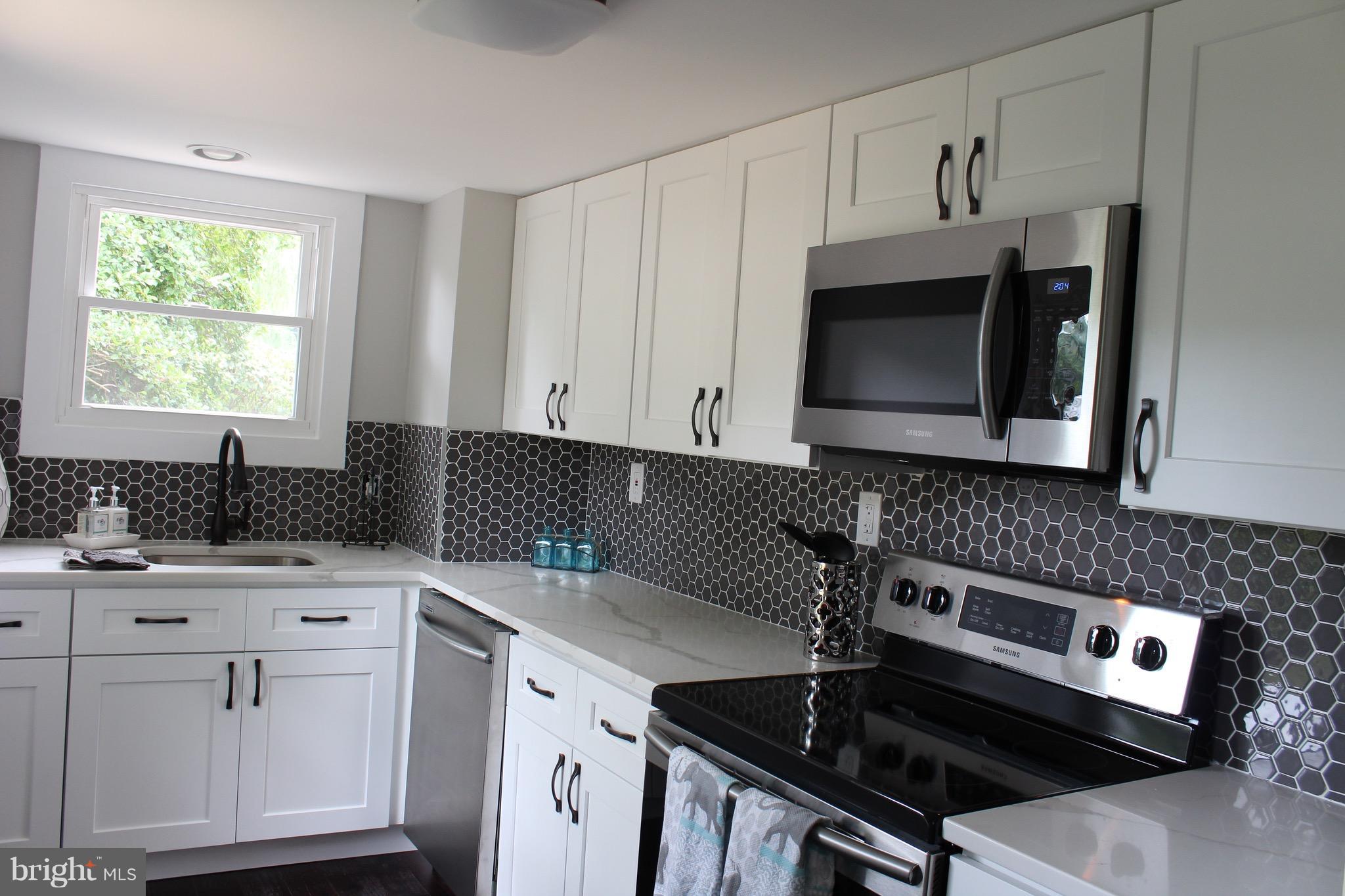 7530 East Battle Grove Road Dundalk, MD 21222 - Photo 4 of 27 a kitchen with stainless steel appliances a sink a stove a microwave a sink and cabinets