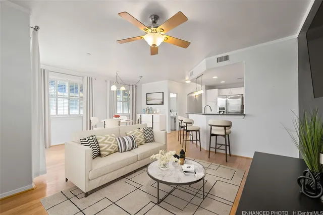 a living room with furniture kitchen view and a potted plant