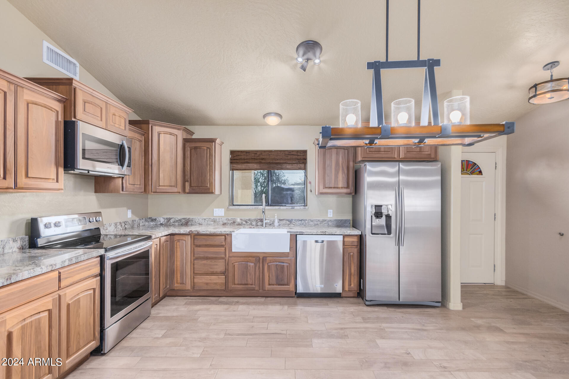 735 North Arroya Road Apache Junction, AZ 85119 - Photo 18 of 70 a kitchen with stainless steel appliances granite countertop a stove a sink dishwasher and a refrigerator
