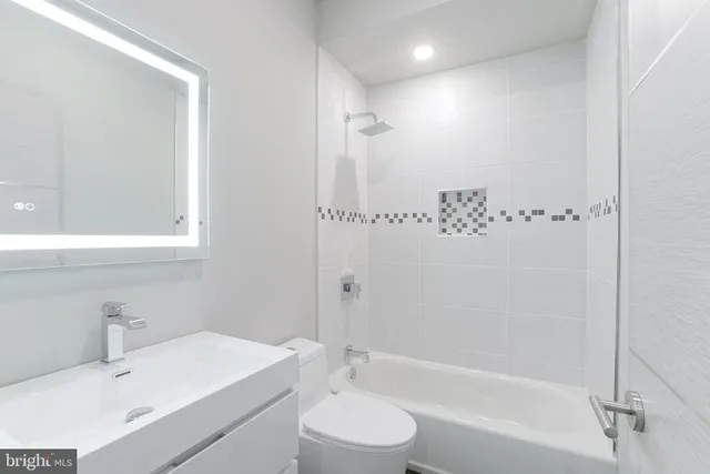 a bathroom with a sink toilet vanity and shower