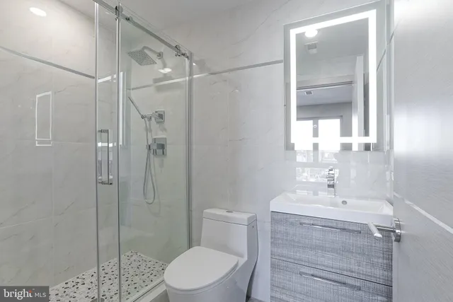 a bathroom with a shower a sink a toilet and shower