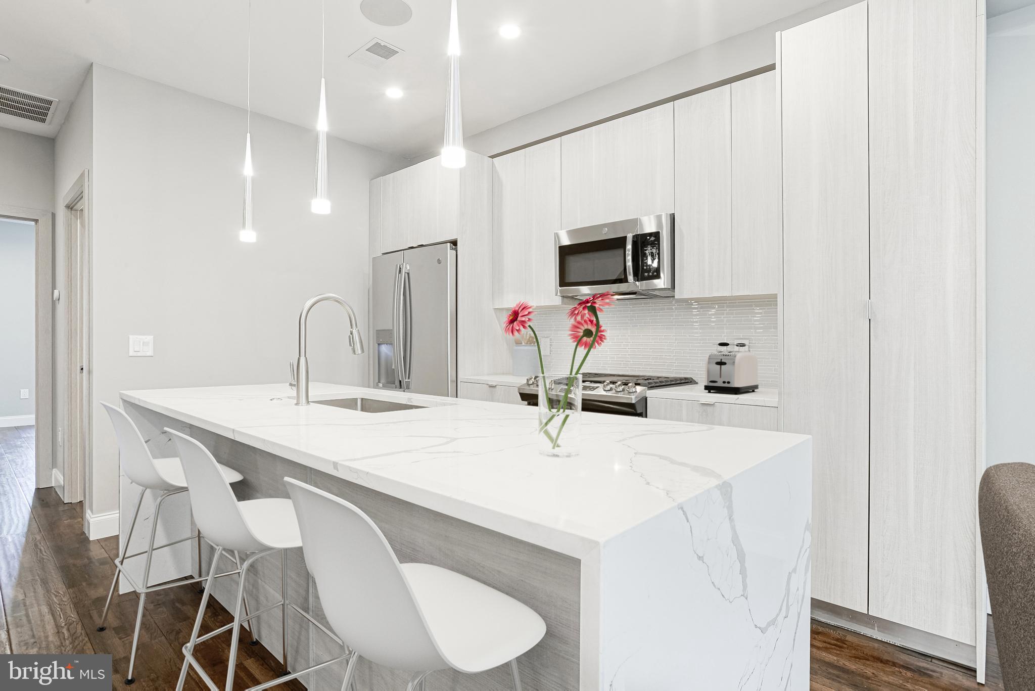1630 Cambridge Street, Unit B Philadelphia, PA 19130 - Photo 4 of 24 a kitchen with a sink a microwave and cabinets