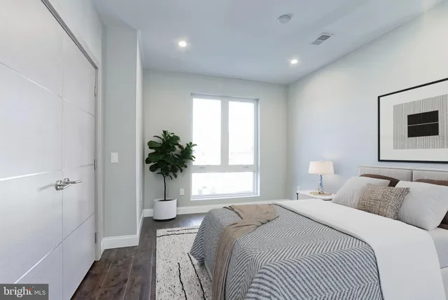 a bedroom with a bed and a potted plant