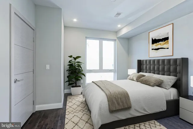 a bedroom with a large bed and a potted plant