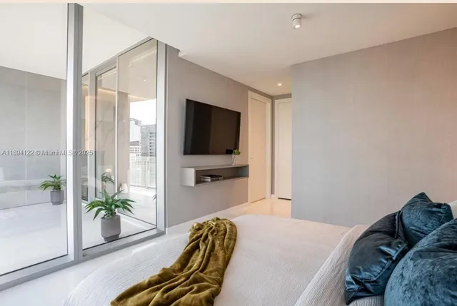 a bedroom with a bed and a large window