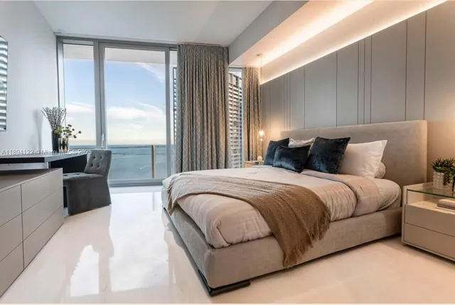 a bed sitting in a bedroom next to a large window with flat screen tv