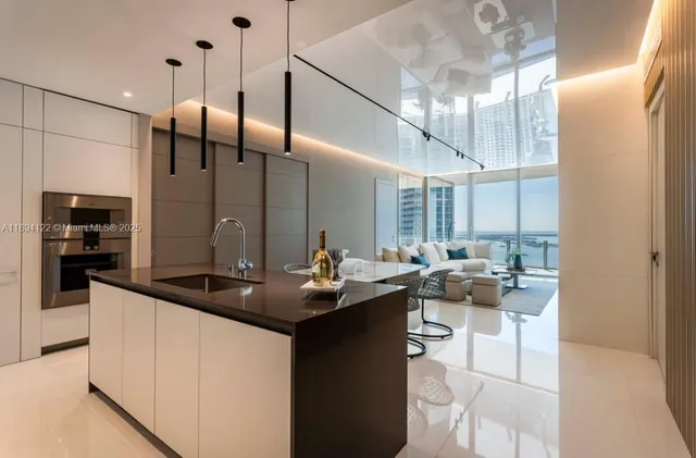 a kitchen with stainless steel appliances kitchen island a table chairs in it and wooden floors