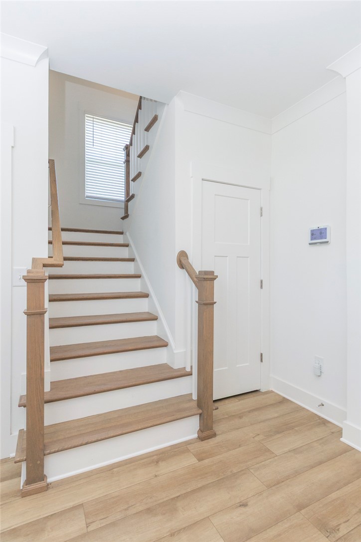607 WH Kay Lane Anderson, SC 29621 - Photo 18 of 48 A well-lit entryway features a modern staircase with natural wood treads and pristine white risers.