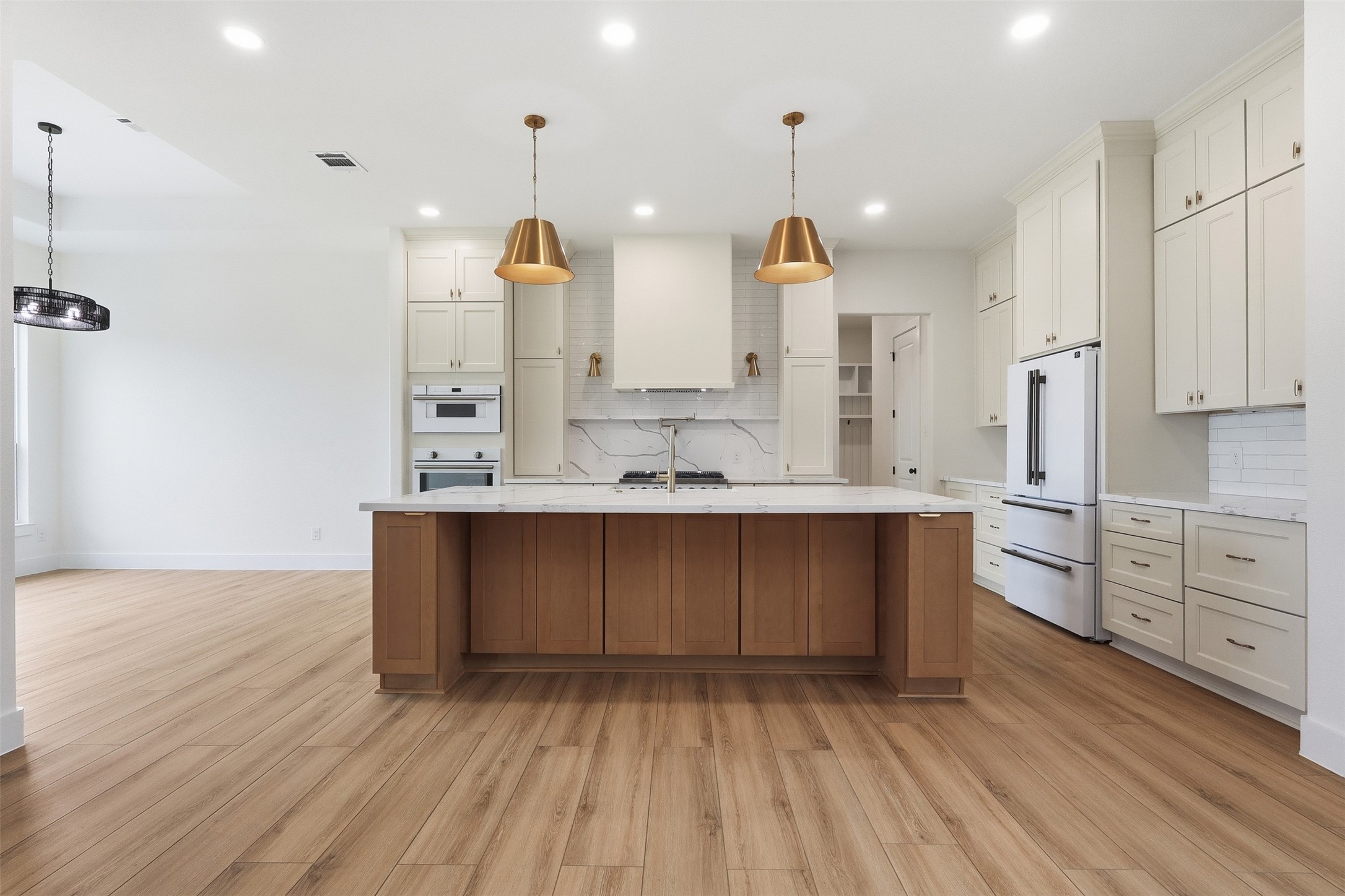 467 Springfield Drive Angleton, TX 77515 - Photo 8 of 42 a large kitchen with kitchen island white cabinets and stainless steel appliances
