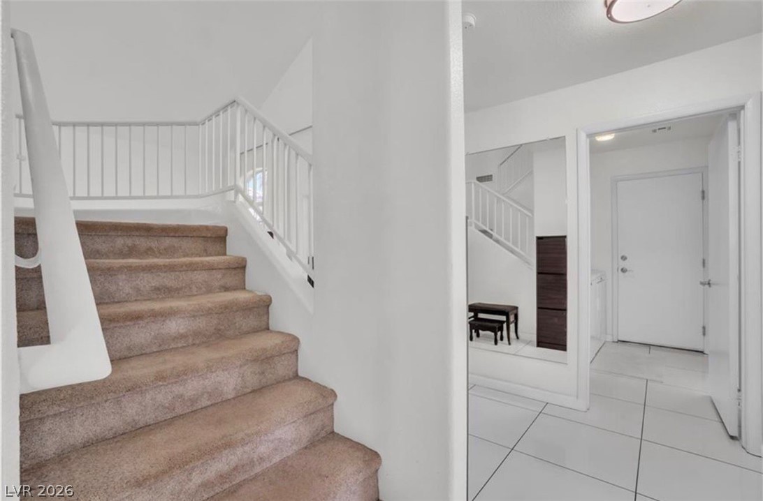 6429 Winding Ridge Las Vegas, NV 89156 - Photo 9 of 22 A split-level entryway features carpeted stairs with a clean white railing.