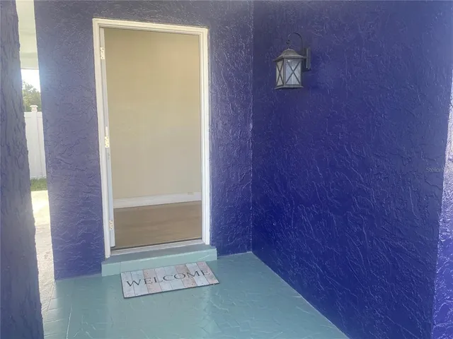 an empty room with wooden floor ceiling fan and windows