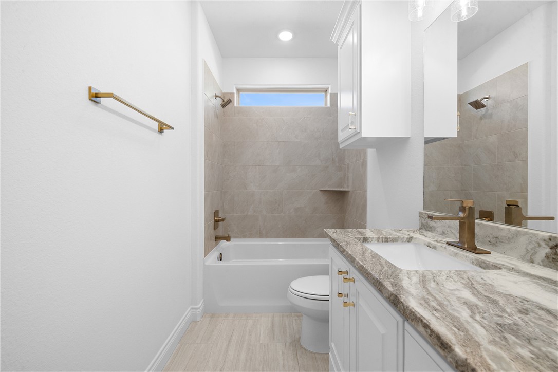 6524 Agave Court Bryan, TX 77808 - Photo 24 of 43 a bathroom with a granite countertop sink a toilet and shower