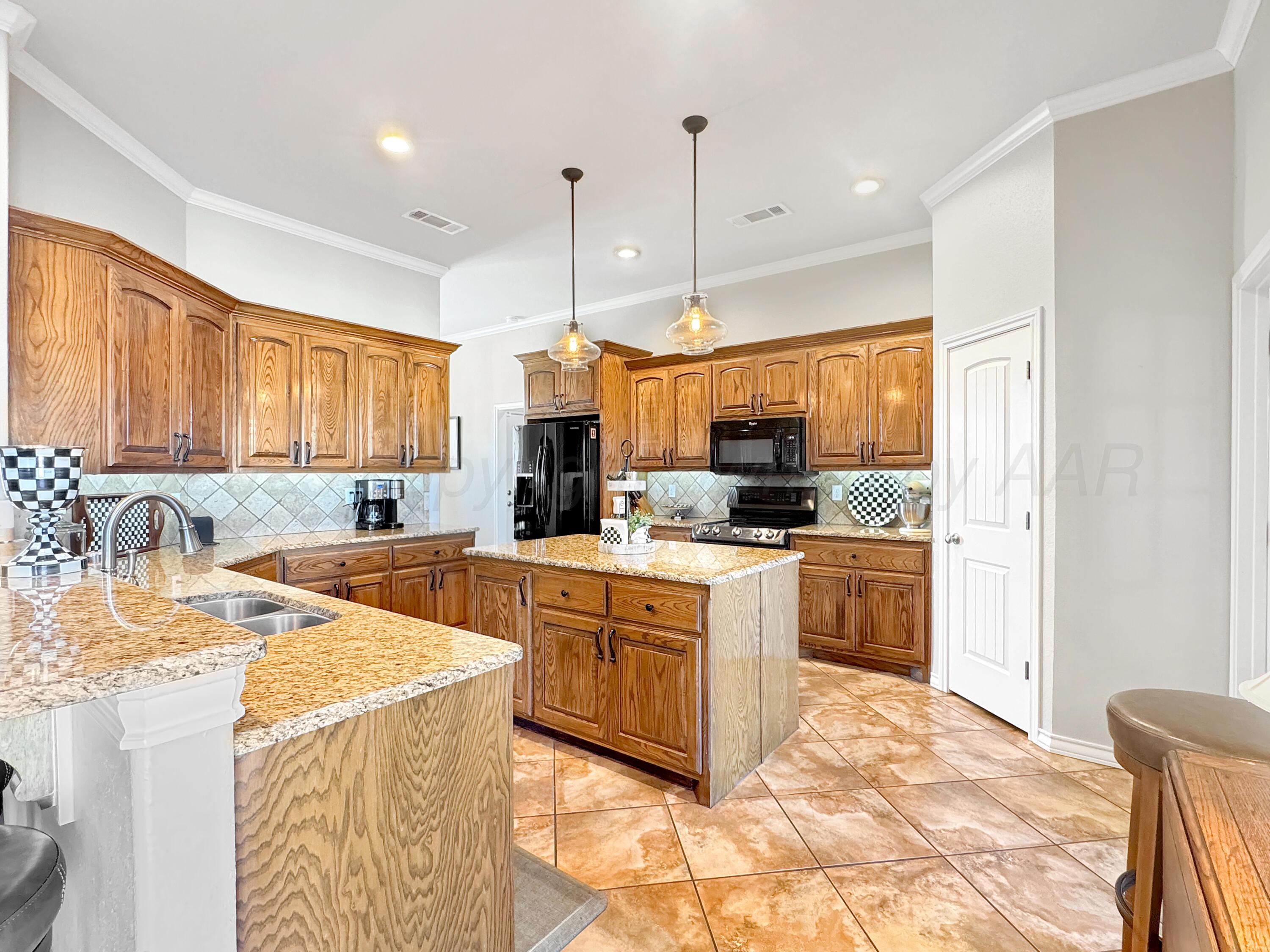 18500 Morning Star Road Bushland, TX 79124 - Photo 11 of 47 a kitchen with stainless steel appliances kitchen island granite countertop a sink a stove and a refrigerator