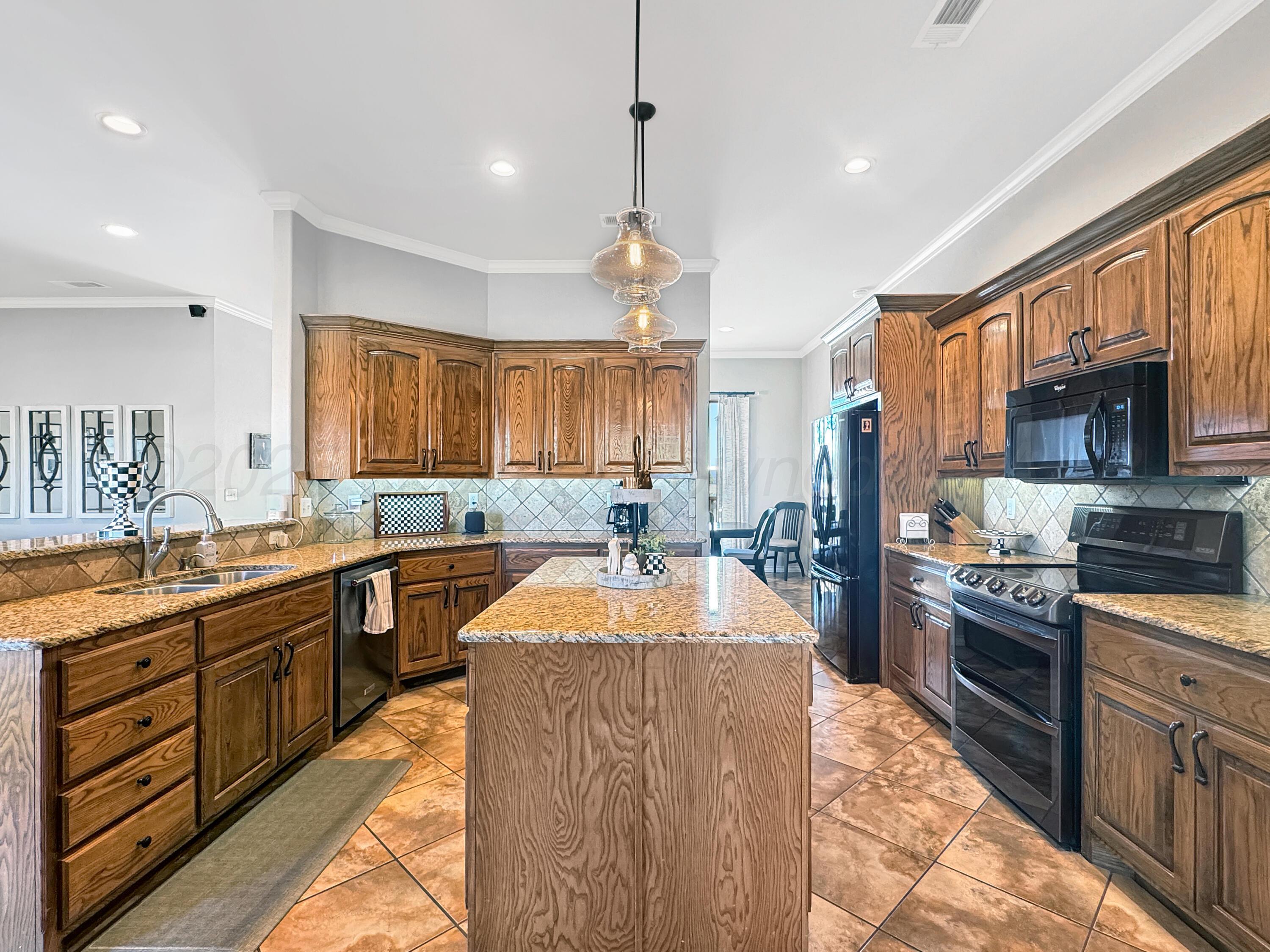 18500 Morning Star Road Bushland, TX 79124 - Photo 12 of 47 a large kitchen with granite countertop a stove top oven a sink a dining table and chairs