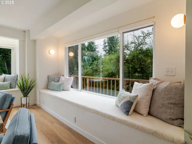 a bed sitting in a balcony next to a large window