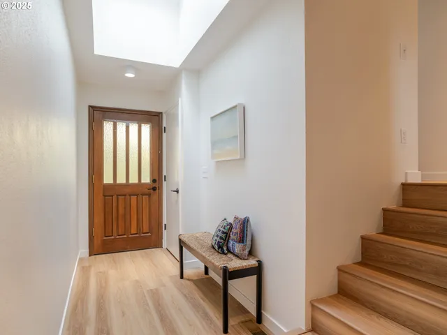 a view of a hallway with wooden floor and stairs