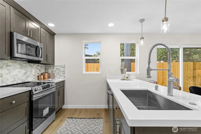a kitchen with stainless steel appliances granite countertop a sink stove and cabinets