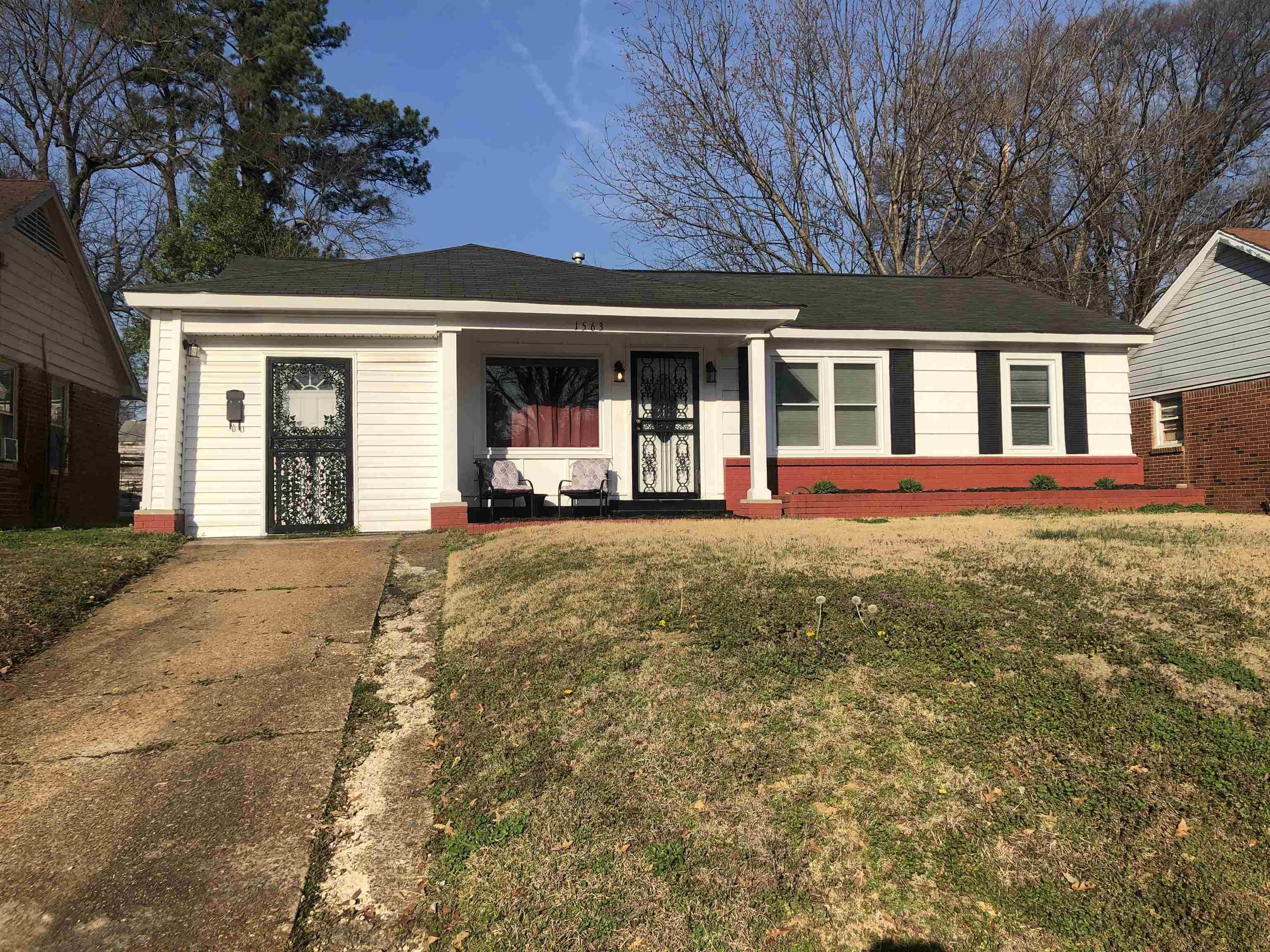 View of front of home featuring covered porch, a front lawn, and roof with shingles