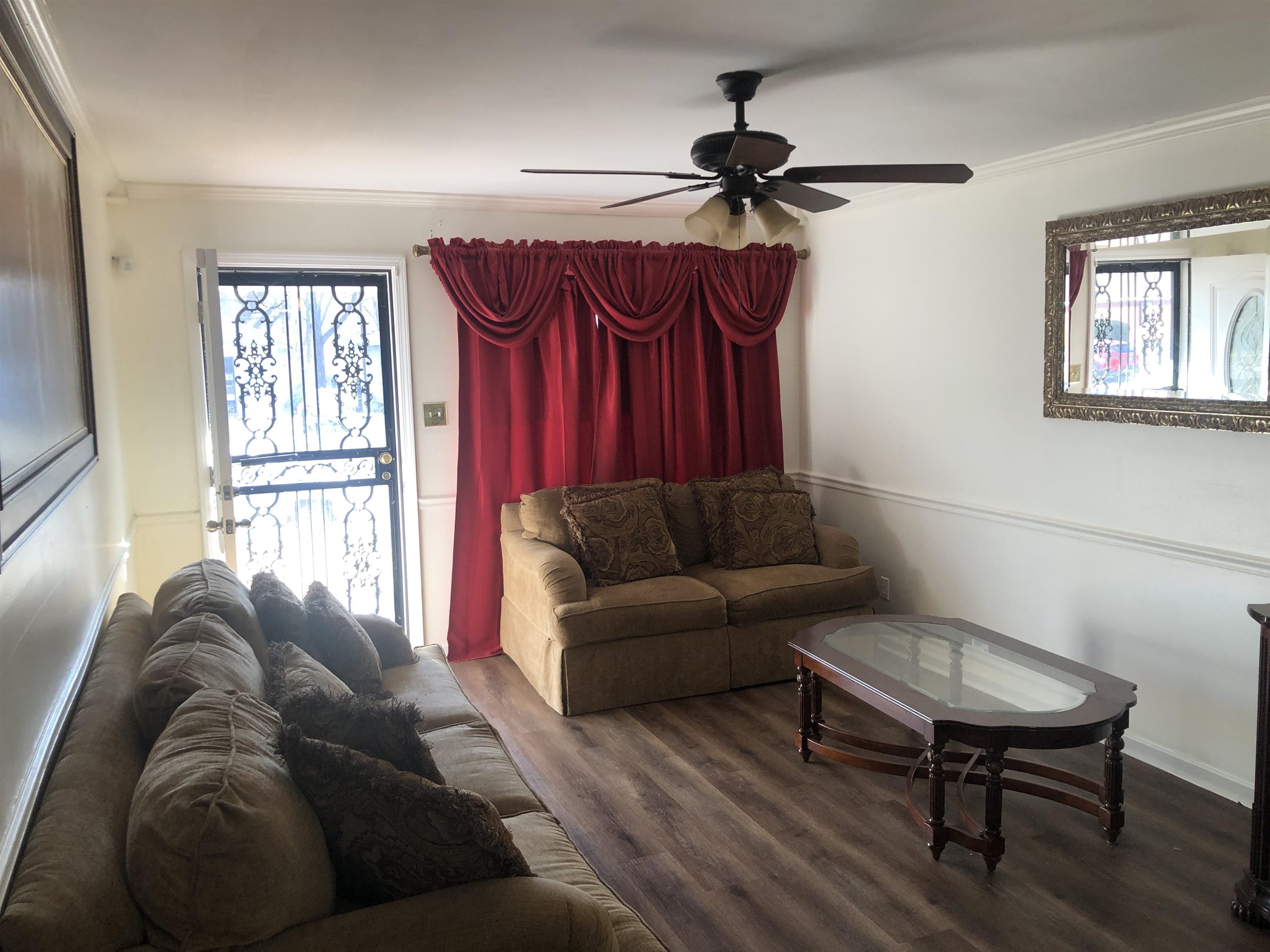 1563 Railton Road Memphis, TN 38111 - Photo 2 of 17 Living room featuring crown molding, a ceiling fan, dark wood finished floors, and healthy amount of natural light