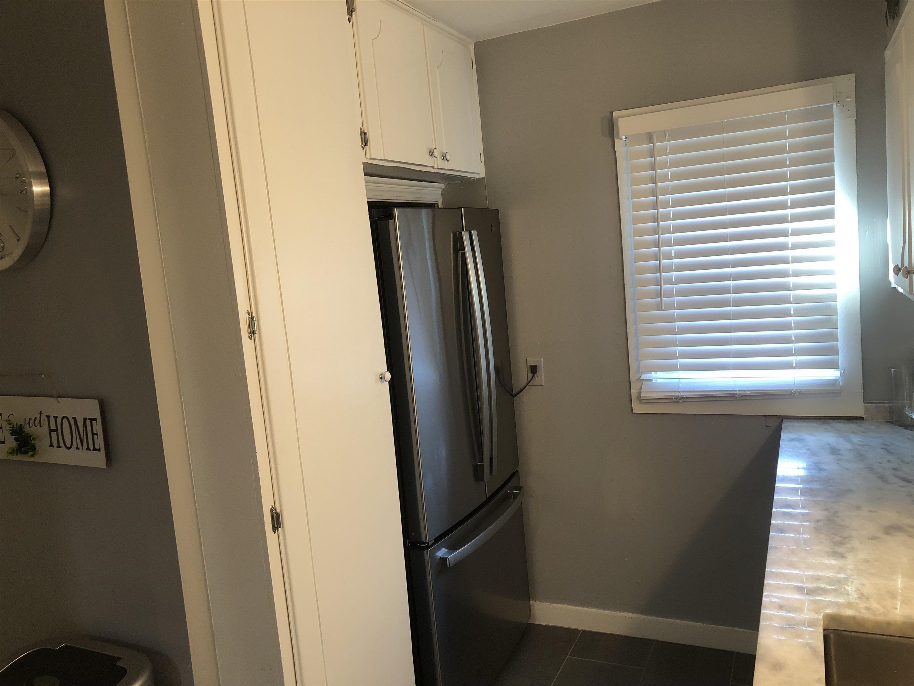 1563 Railton Road Memphis, TN 38111 - Photo 5 of 17 Kitchen with freestanding refrigerator, white cabinets, and dark tile patterned floors