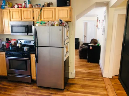 a kitchen with a refrigerator and a stove top oven
