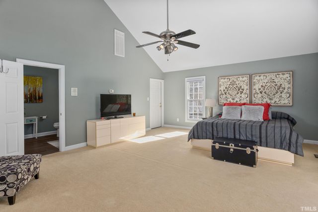 a spacious bedroom with a bed and a chandelier