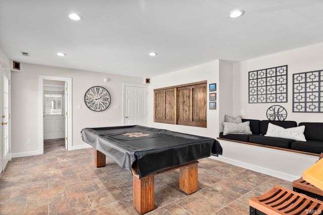 a living room with stainless steel appliances furniture and a flat screen tv