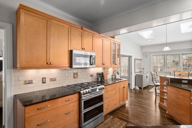 a kitchen with stainless steel appliances granite countertop a stove a sink and a refrigerator