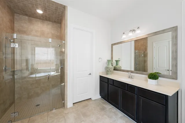 a spacious bedroom with a bed and a lamp on table