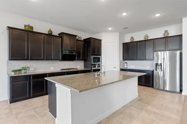 a kitchen with stainless steel appliances granite countertop a sink stove and refrigerator