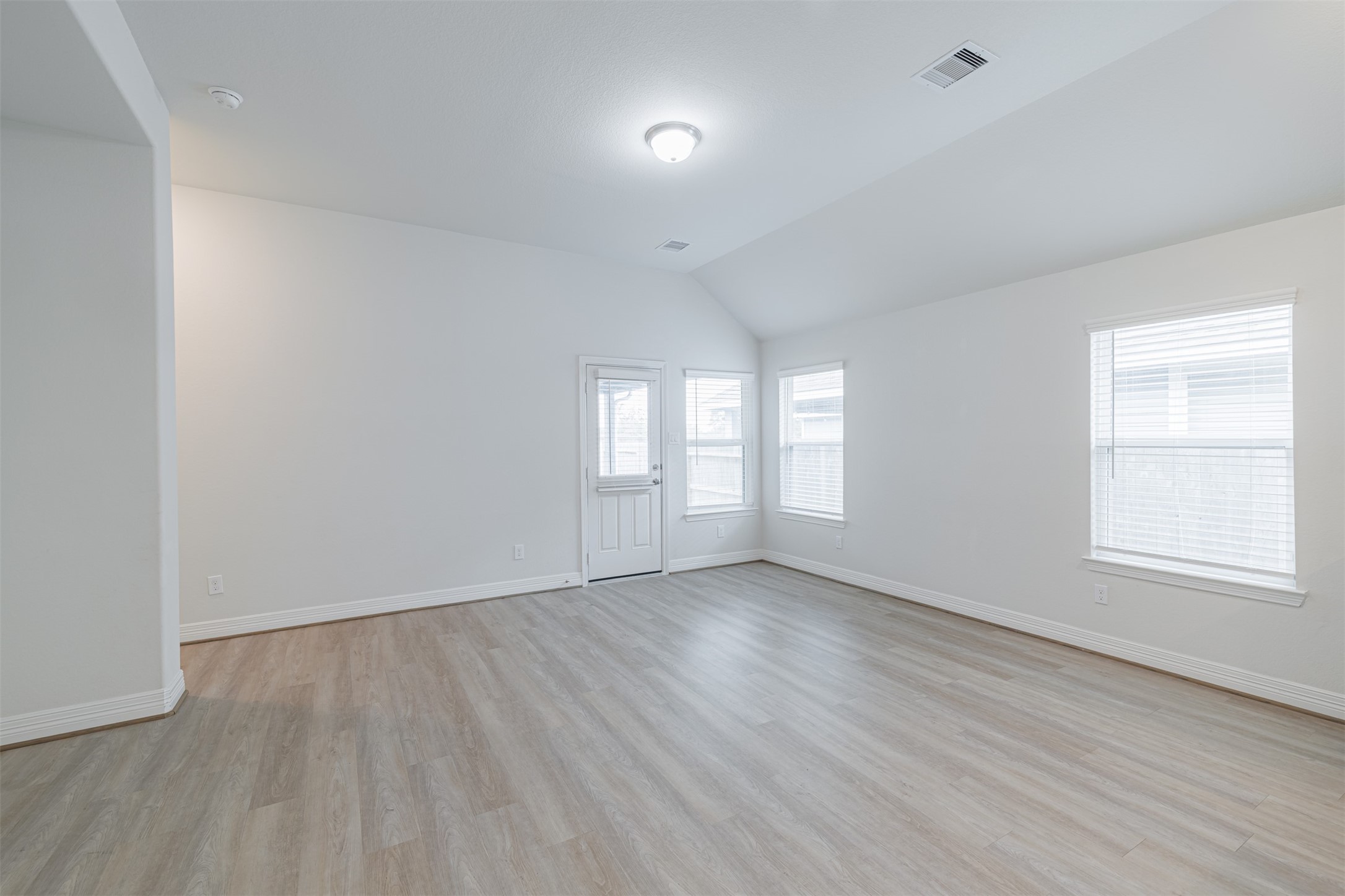 33118 School Hl Road Fulshear, TX 77441 - Photo 11 of 18 an empty room with wooden floor and windows