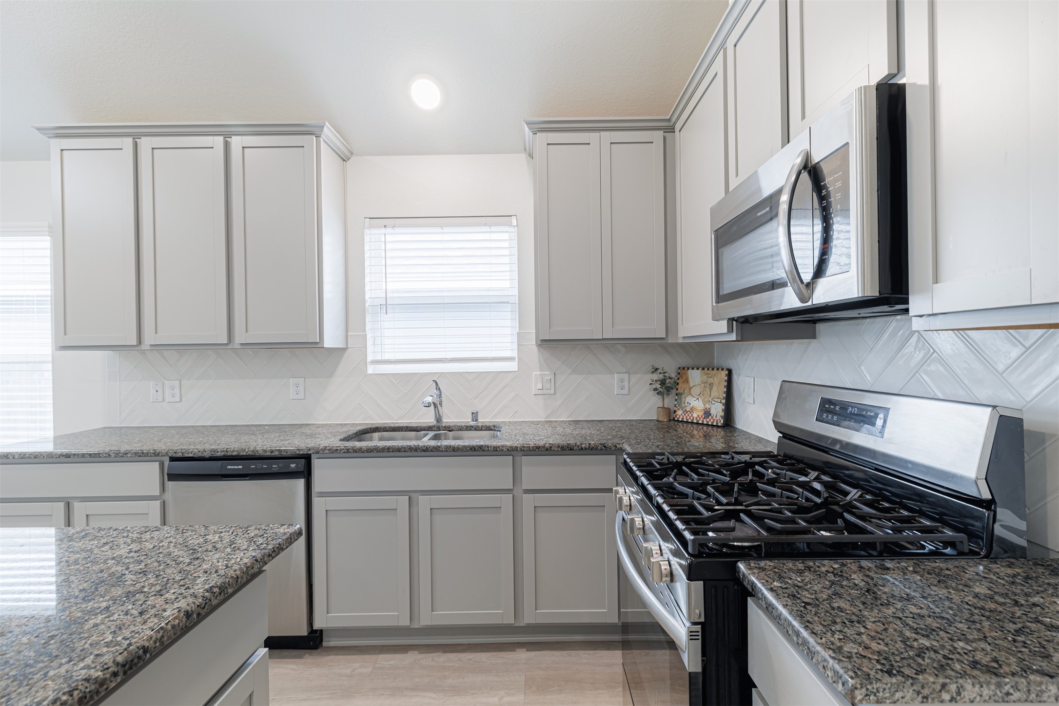 33118 School Hl Road Fulshear, TX 77441 - Photo 8 of 18 a kitchen with granite countertop a sink stove and cabinets