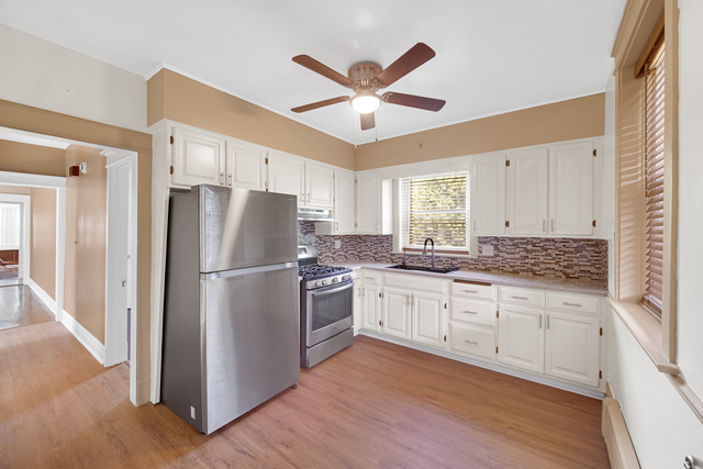 1007 South Austin Boulevard, Unit 1 Chicago, IL 60644 - Photo 13 of 15 a kitchen with granite countertop a refrigerator a sink and white cabinets